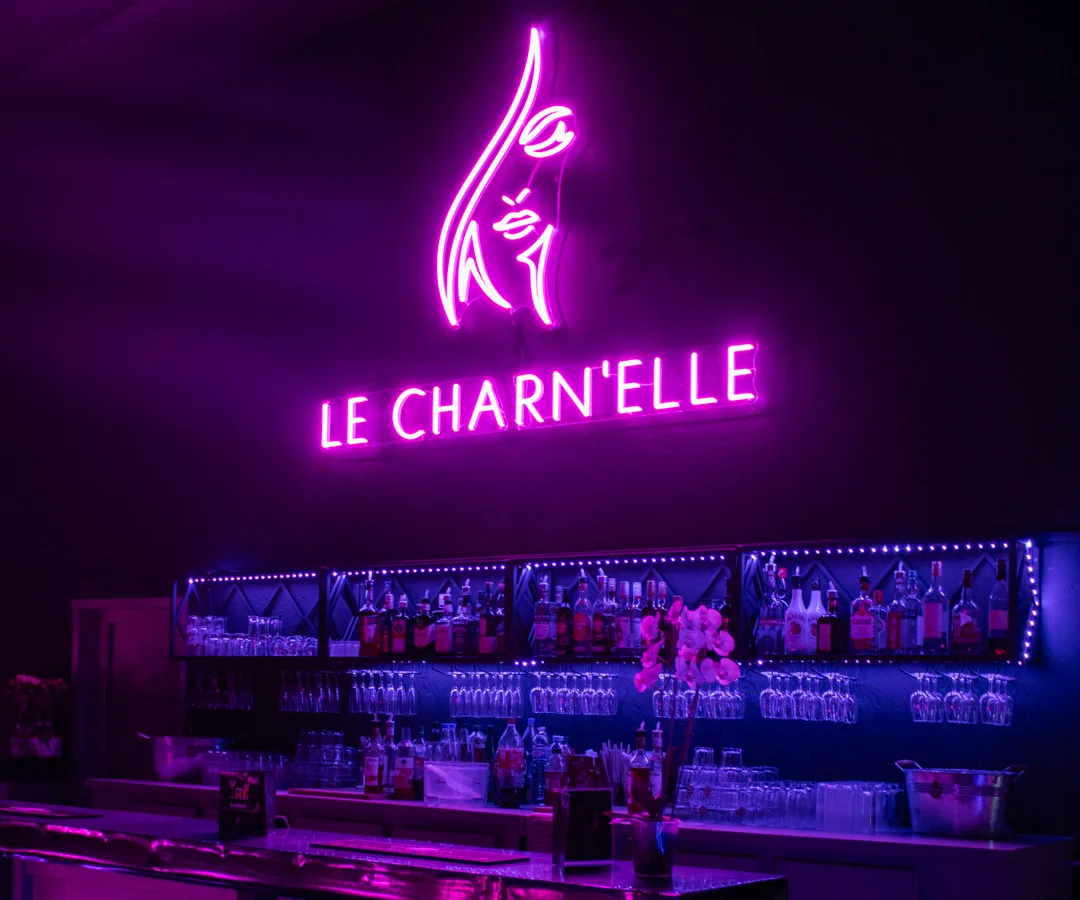 Bar du Charn’elle sous l’enseigne néon rose Le Charn’elle