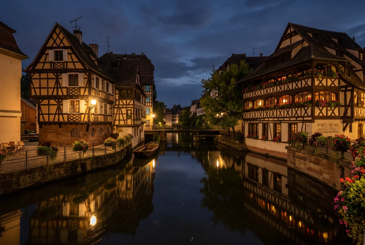 Maisons à colombages de la Petite France à Strasbourg, reflétées dans le canal la nuit