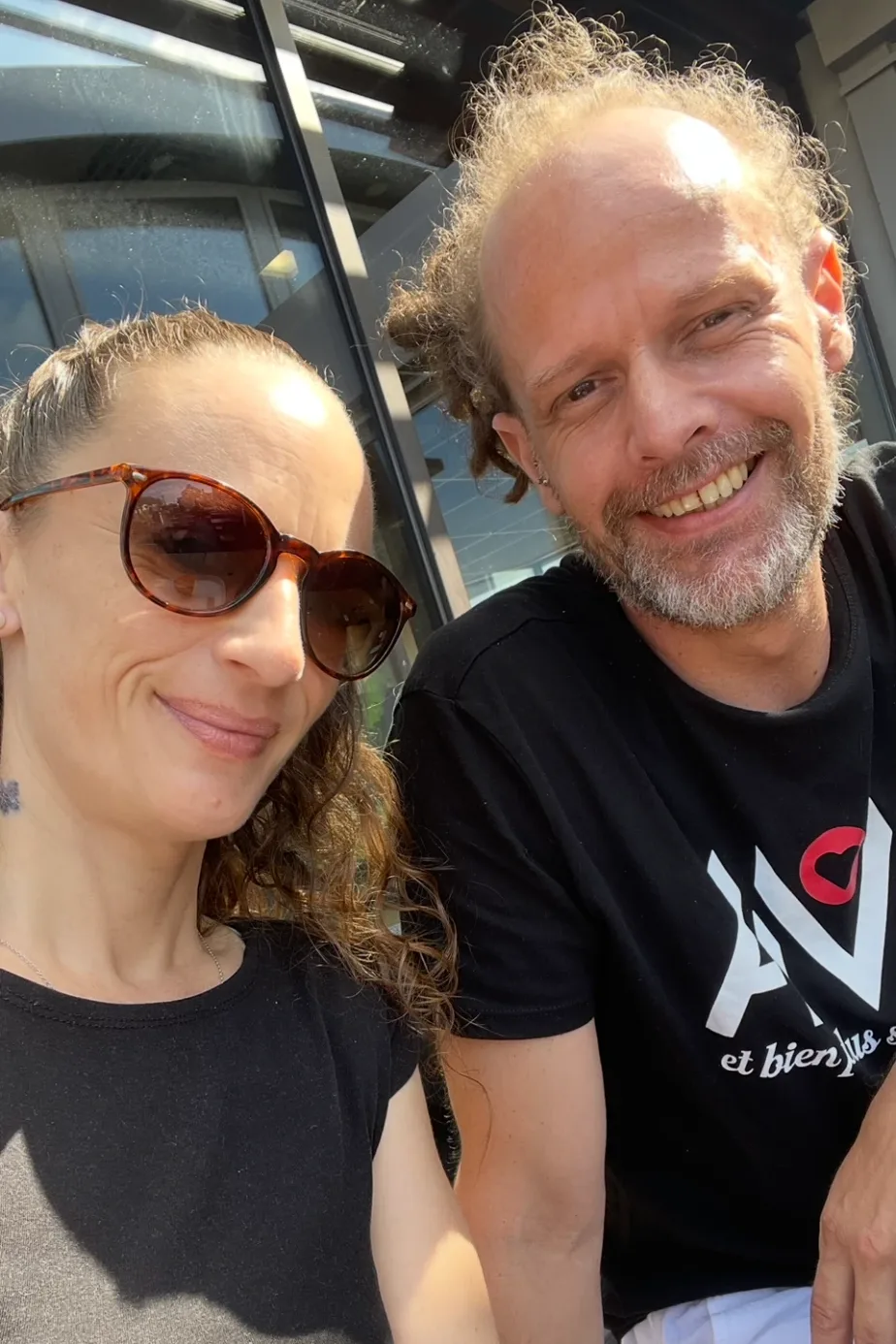 Selfie de Mini Chouquette 72 au soleil, elle en lunettes de soleil, lui souriant en t-shirt noir
